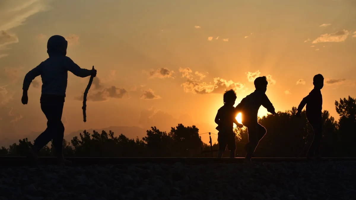 Nens jugant a l’aire lliure al capvespre sense pantalles, desconnexió digital en família